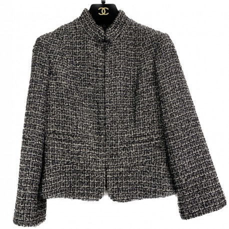 Veste T34 CHANEL en tweed noir et blanc avec fil doré. Fermeture avec zip et deux poches passepoilées sur le devant